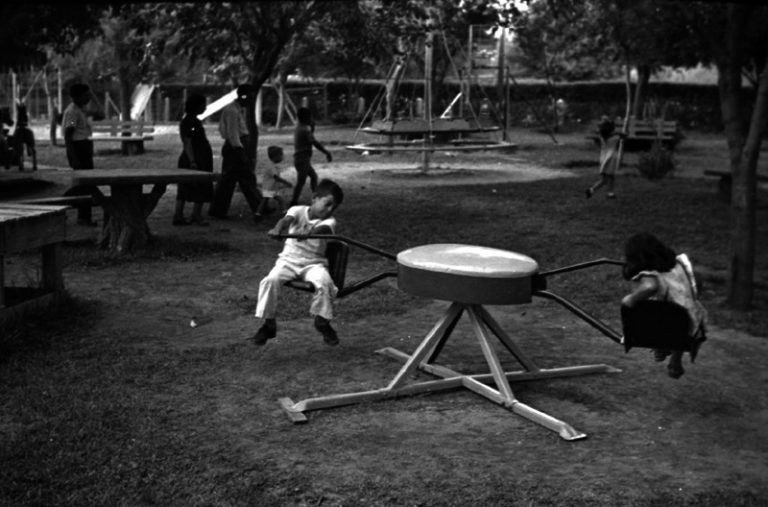 Niños jugando en juegos mecánicos de un parque infantil, Ca 1955. Casasola